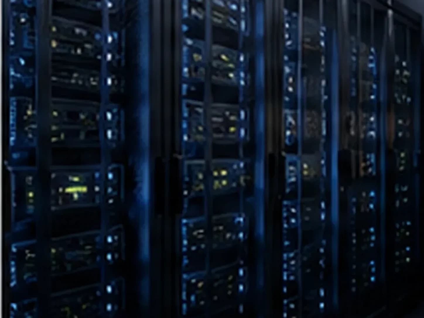 Rows of lit server racks receding into a dark, cool-lit infrastructure room.